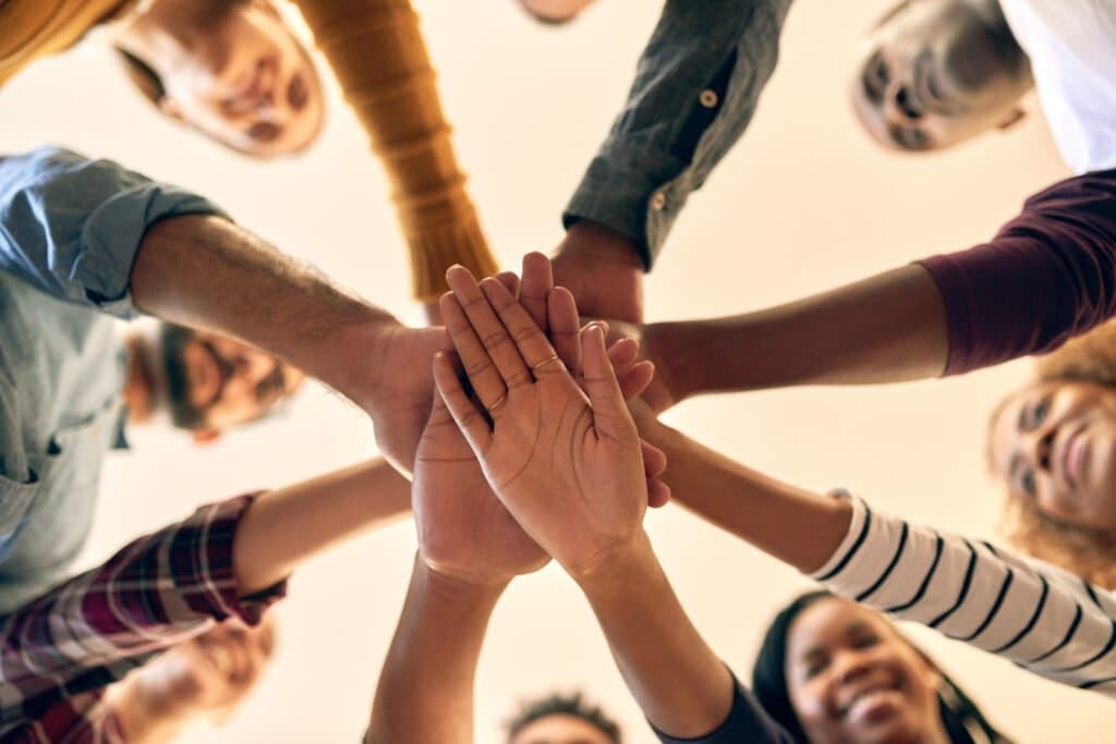 Team legt Hände zusammen als Symbol für Verlässlichkeit.